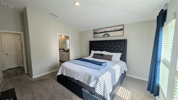 a bed sitting in a bedroom next to a window