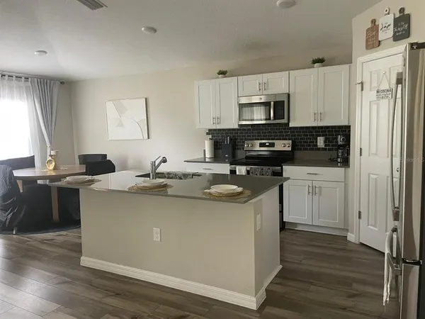 a kitchen with stainless steel appliances a sink stove refrigerator and cabinets