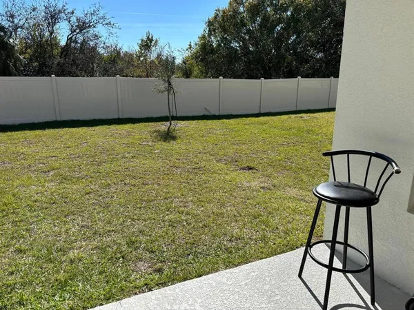 a backyard of a house with table and chairs