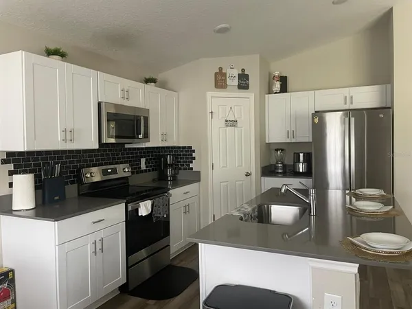 a kitchen with a refrigerator stove and microwave