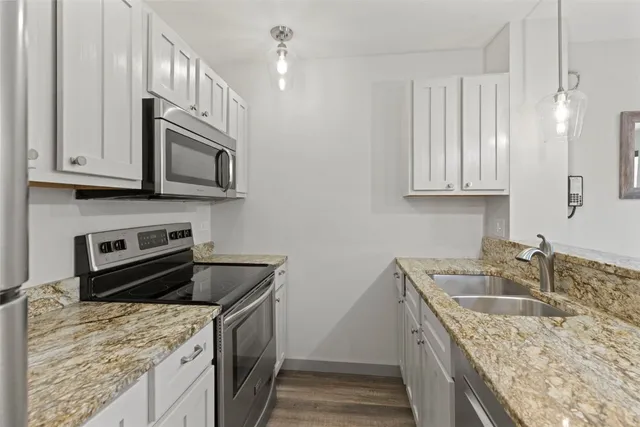 a kitchen with stainless steel appliances granite countertop a sink stove and microwave