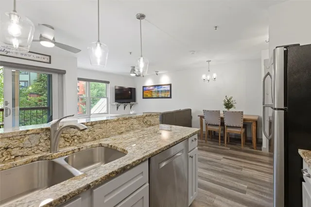 a kitchen with stainless steel appliances granite countertop a sink a stove and a refrigerator