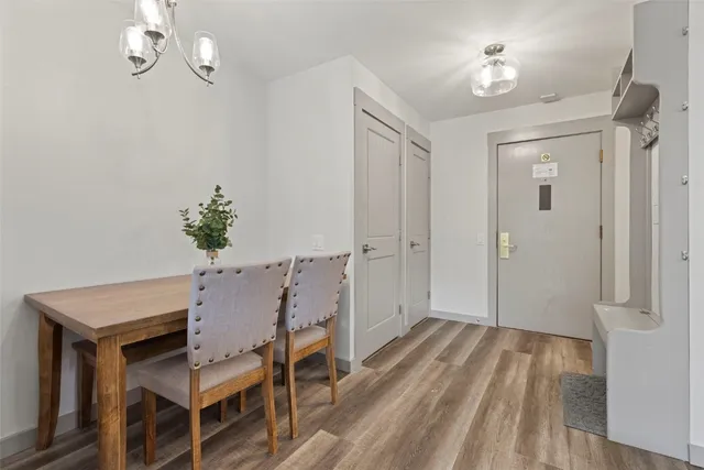 a view of a room with wooden floor table and chairs