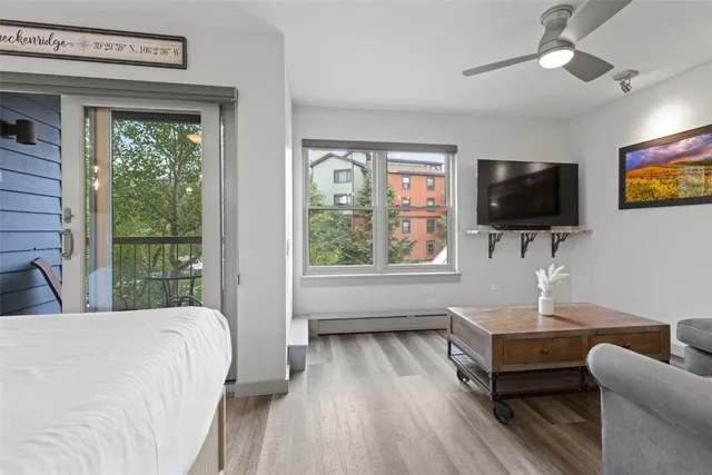 a living room with furniture a flat screen tv and a large window
