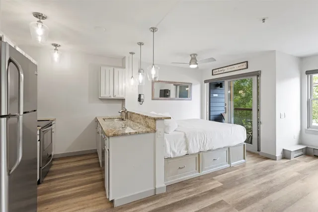 a spacious bedroom with a bed dresser and a window