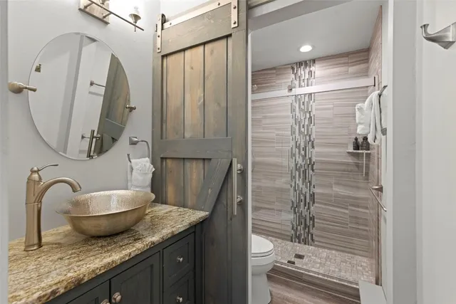 a bathroom with a granite countertop sink toilet and shower