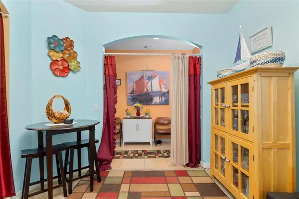 a living room with furniture kitchen view and a large window
