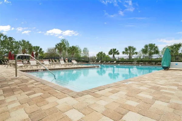 a view of swimming pool with yard and lake view in back
