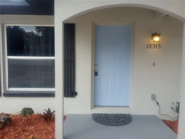 a view of a hallway with bed and wooden floor
