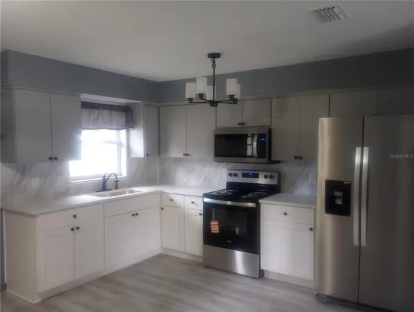 a kitchen with stainless steel appliances a sink stove and refrigerator