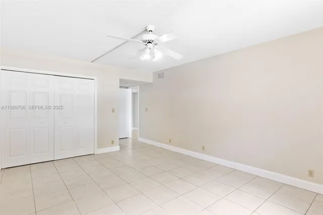 an empty room with closet and fan