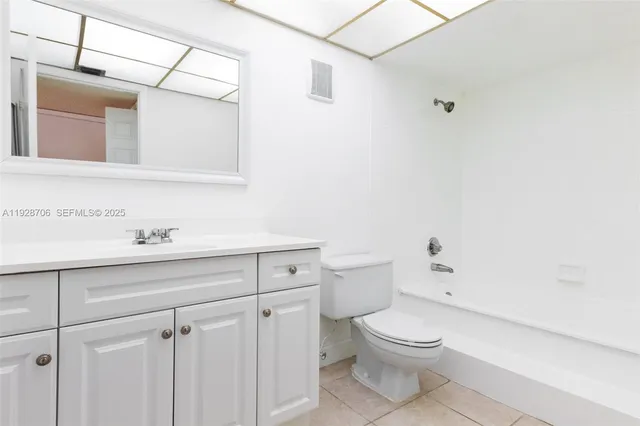 a bathroom with a toilet a sink a mirror and vanity