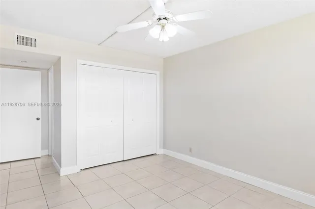 an empty room with a ceiling fan and a window