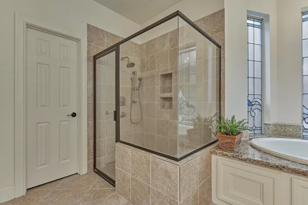 a bathroom with a granite countertop shower sink and mirror
