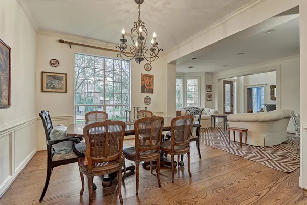 a view of a dining room with furniture a chandelier and wooden floor