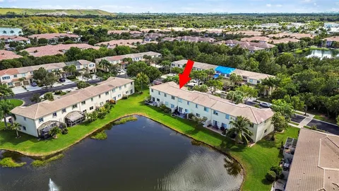an aerial view of a house with a garden and lake view