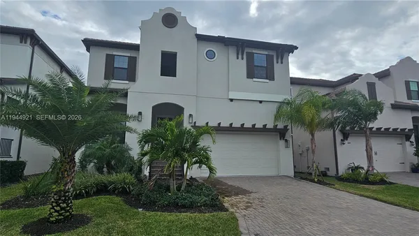 front view of house with a yard and potted plants
