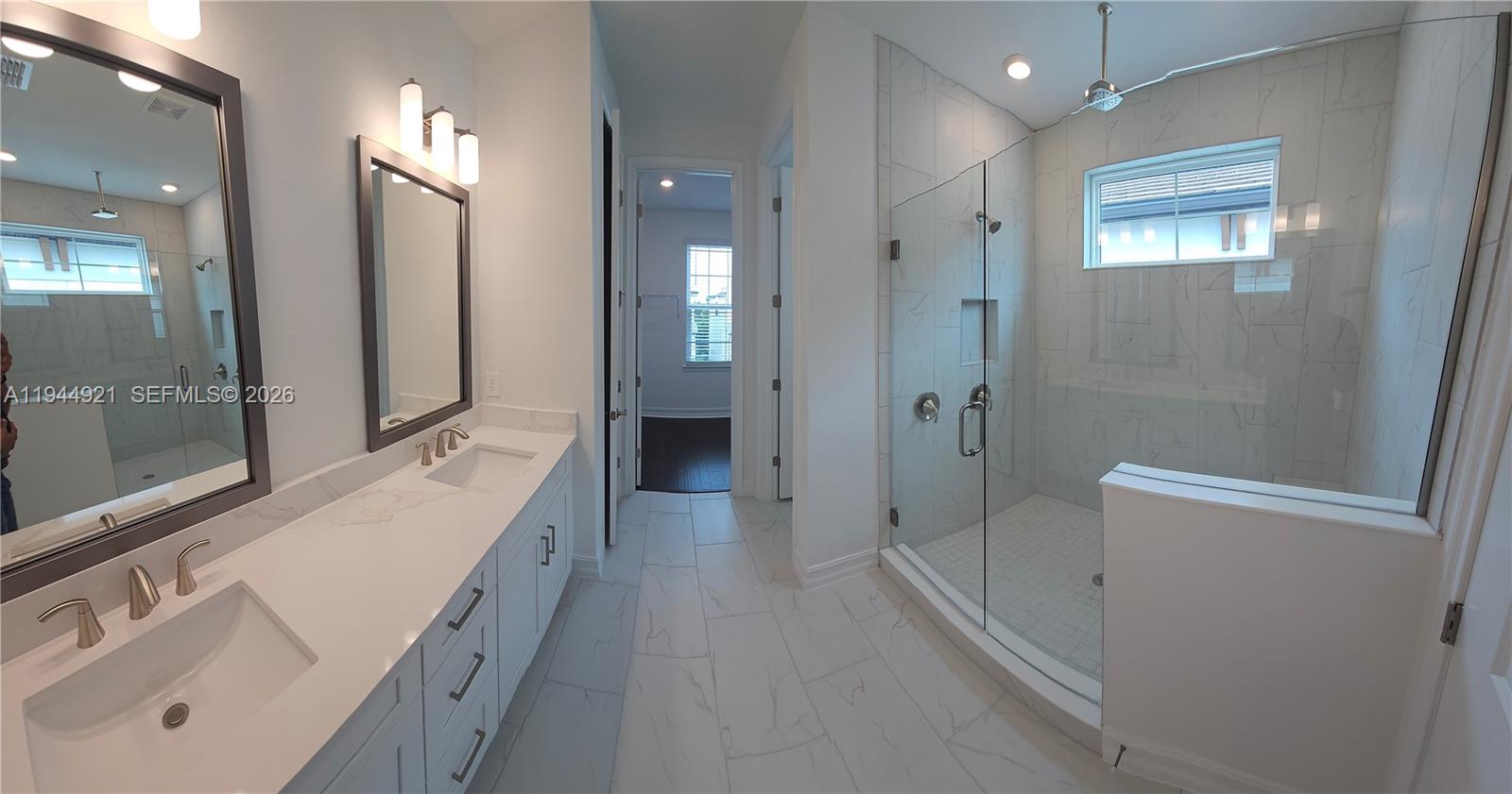 1112 Seagrape Drive Ruskin, FL 33570 - Photo 6 of 18 a bathroom with a sink a mirror and a shower