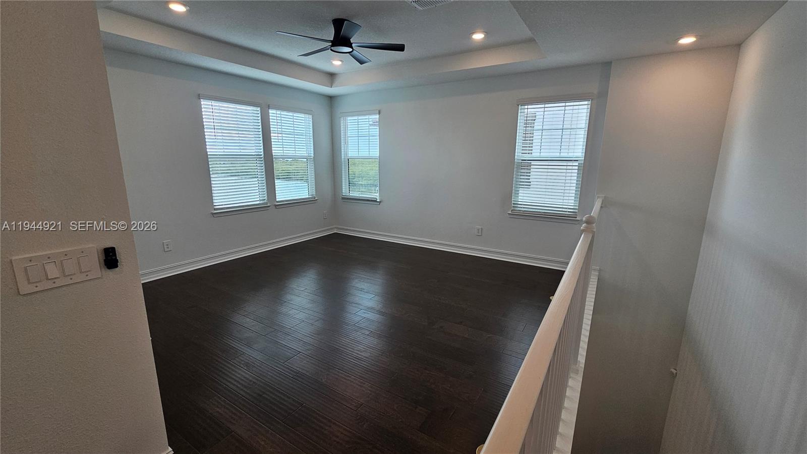 1112 Seagrape Drive Ruskin, FL 33570 - Photo 8 of 18 an empty room with wooden floor fan and windows
