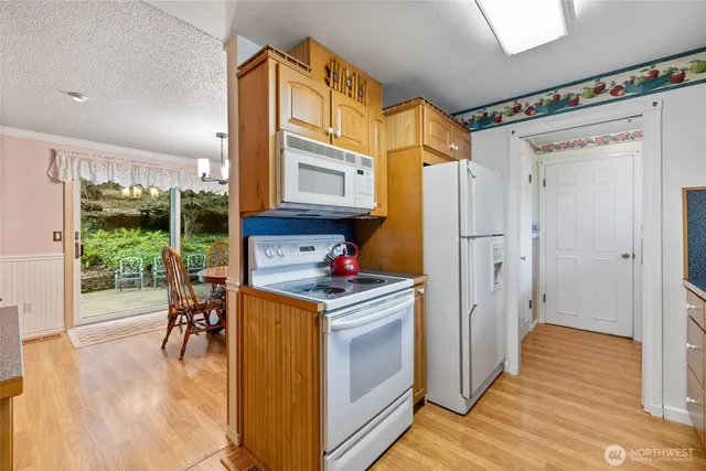 a kitchen that has a stove and a wooden floor