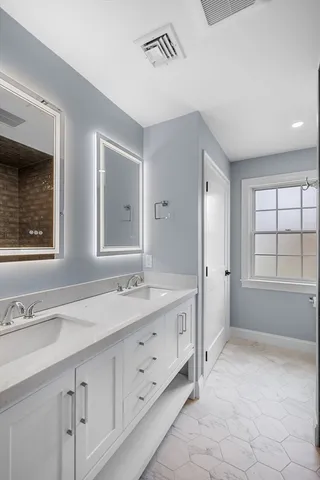 a spacious bathroom with a granite countertop sink mirror and double