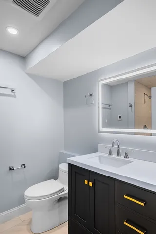 a bathroom with a sink a toilet and a mirror