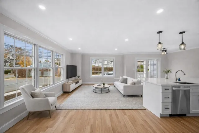 a living room with furniture wooden floor and a large window