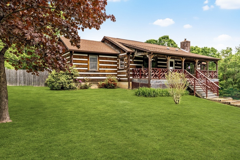 a backyard of a house with potted plants and large tree