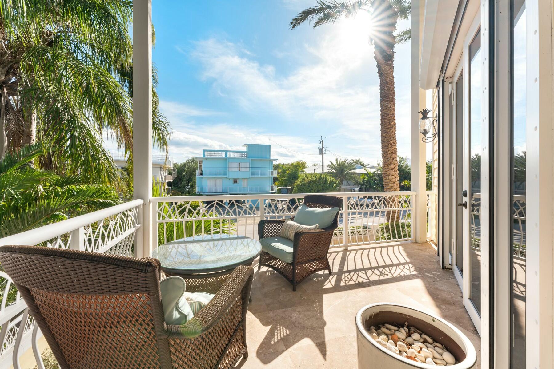141 Canal Street Tavernier, FL 33070 - Photo 12 of 90 a view of a chair and tables in the balcony