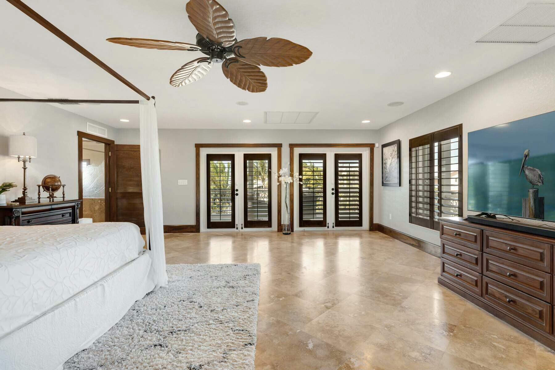 141 Canal Street Tavernier, FL 33070 - Photo 32 of 90 a spacious bedroom with a large bed and ceiling fan