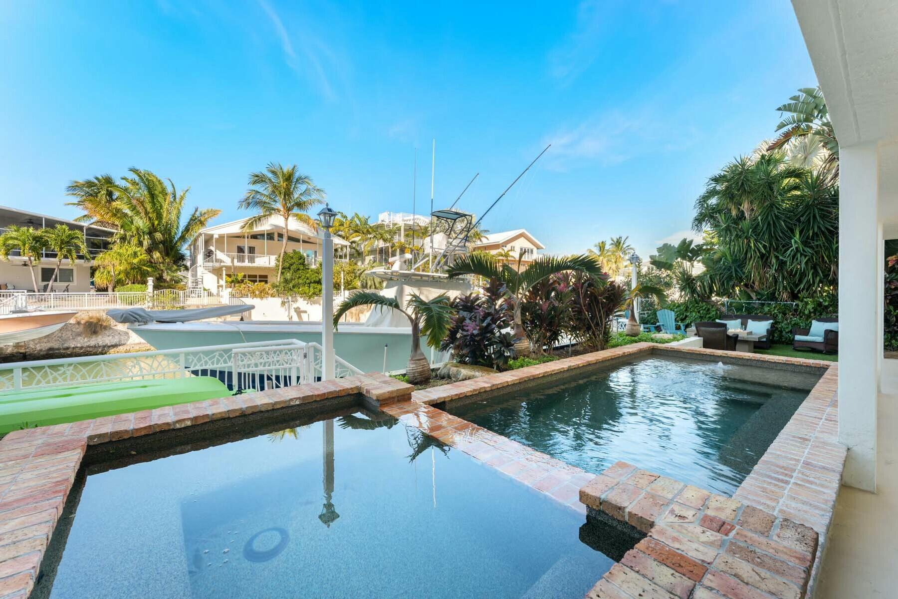 141 Canal Street Tavernier, FL 33070 - Photo 60 of 90 a view of swimming pool with outdoor seating and plants