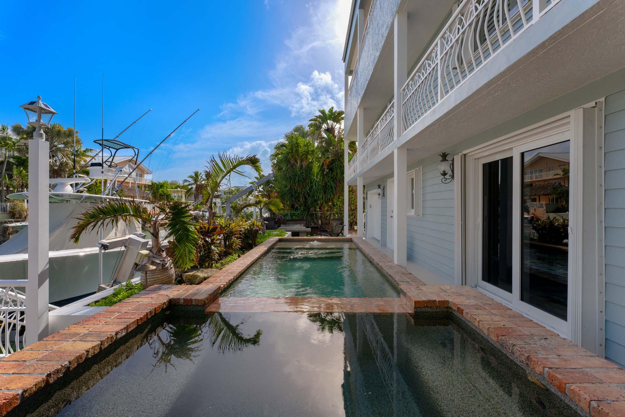 141 Canal Street Tavernier, FL 33070 - Photo 83 of 90 a swimming pool with outdoor seating and yard