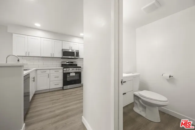a kitchen with a sink a toilet and cabinets
