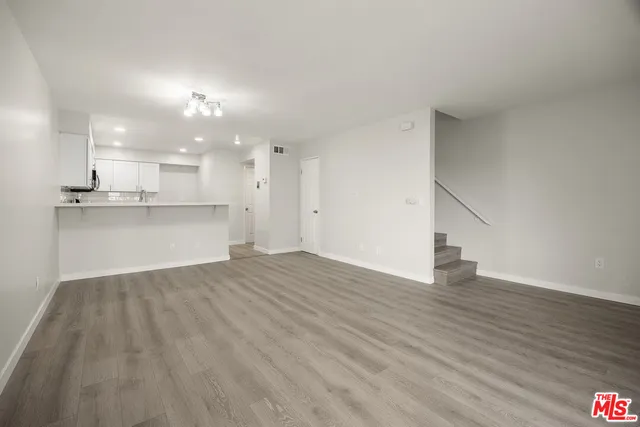 a view of kitchen with wooden floor and electronic appliances