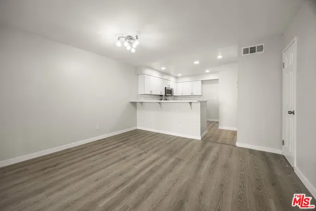 a view of large kitchen with wooden floor and electronic appliances