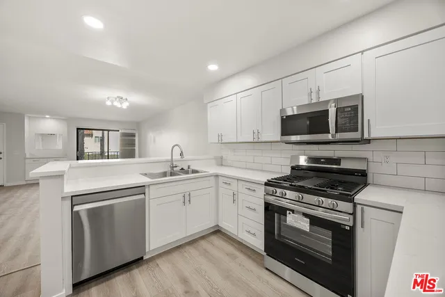 a kitchen with sink a microwave and cabinets
