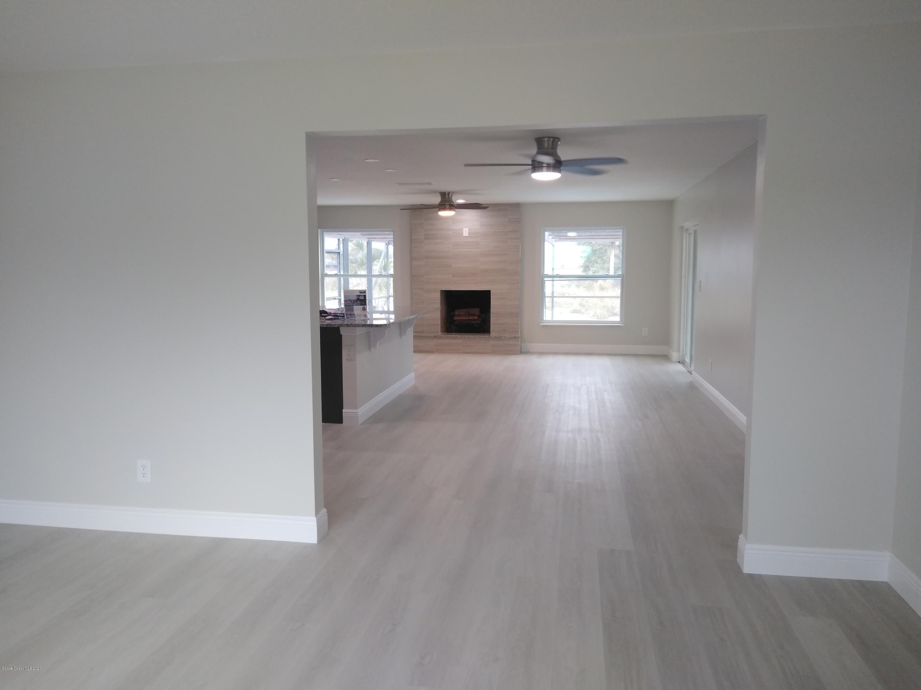 770 Montclair Road Northeast, Unit 1 Palm Bay, FL 32905 - Photo 15 of 23 wooden floor in an empty room with a fireplace