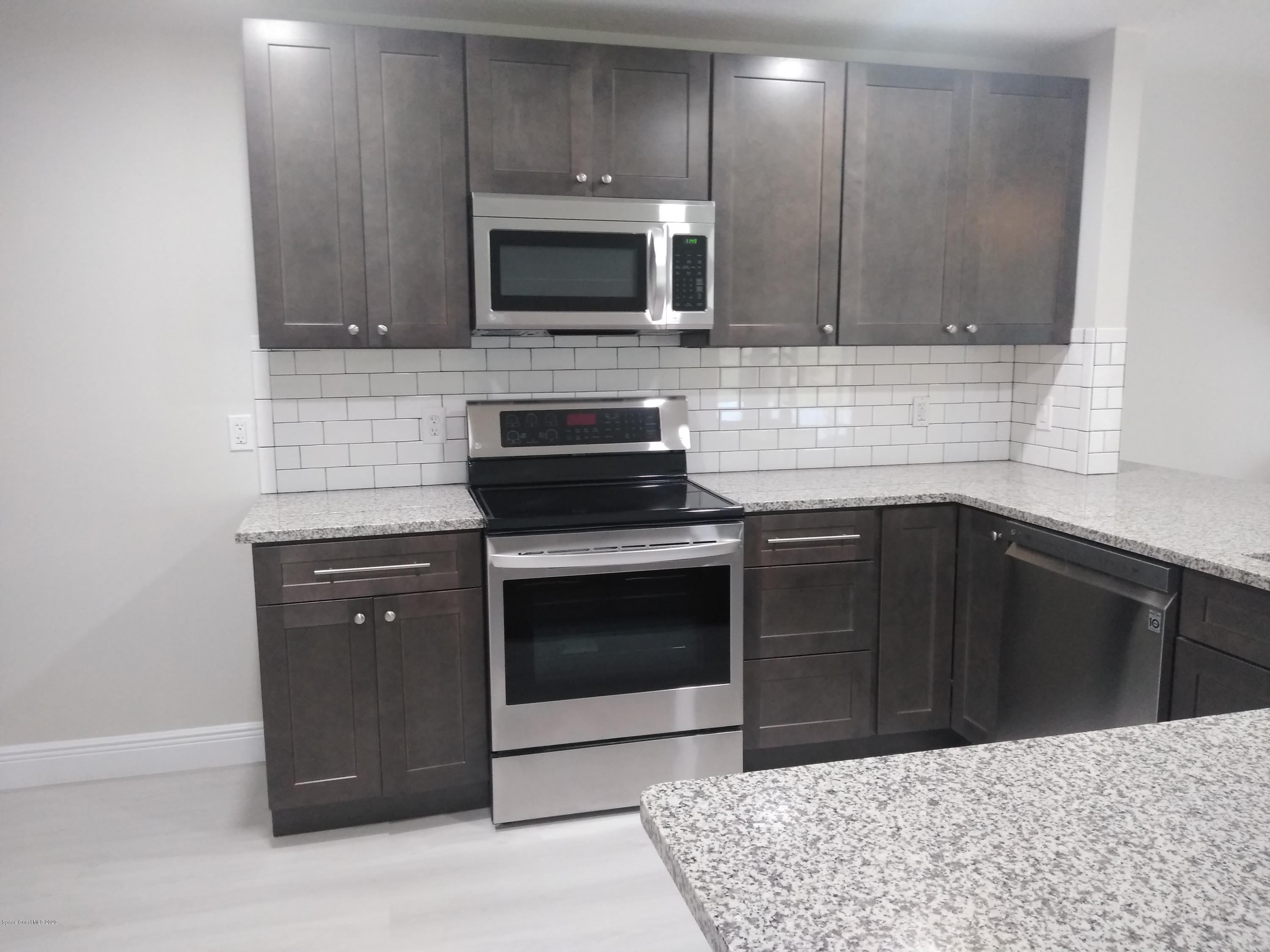 770 Montclair Road Northeast, Unit 1 Palm Bay, FL 32905 - Photo 18 of 23 a kitchen with a sink stove and microwave