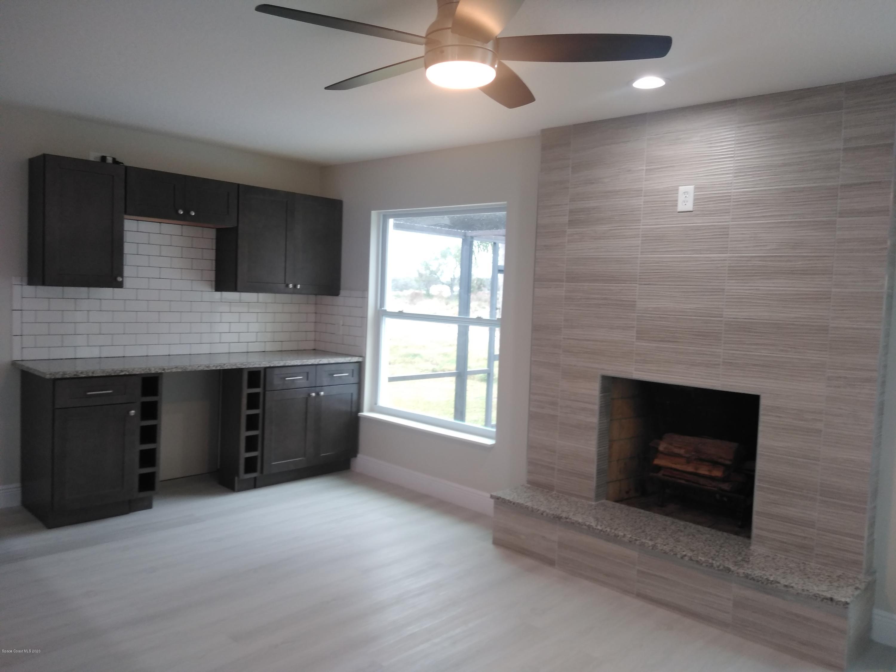 770 Montclair Road Northeast, Unit 1 Palm Bay, FL 32905 - Photo 19 of 23 a living room with stainless steel appliances granite countertop furniture a fireplace and a flat screen tv