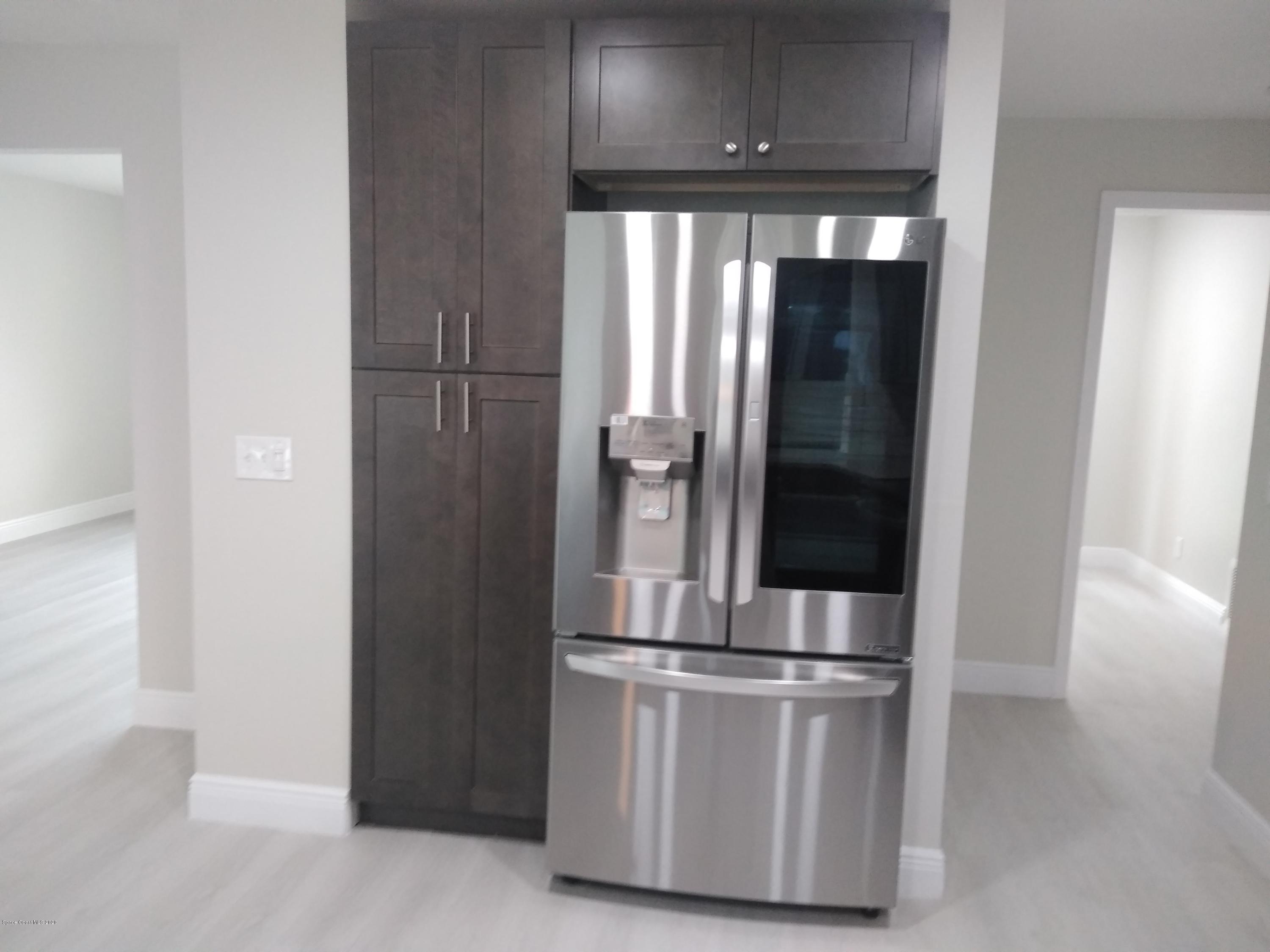 770 Montclair Road Northeast, Unit 1 Palm Bay, FL 32905 - Photo 21 of 23 a metallic refrigerator freezer sitting in a kitchen