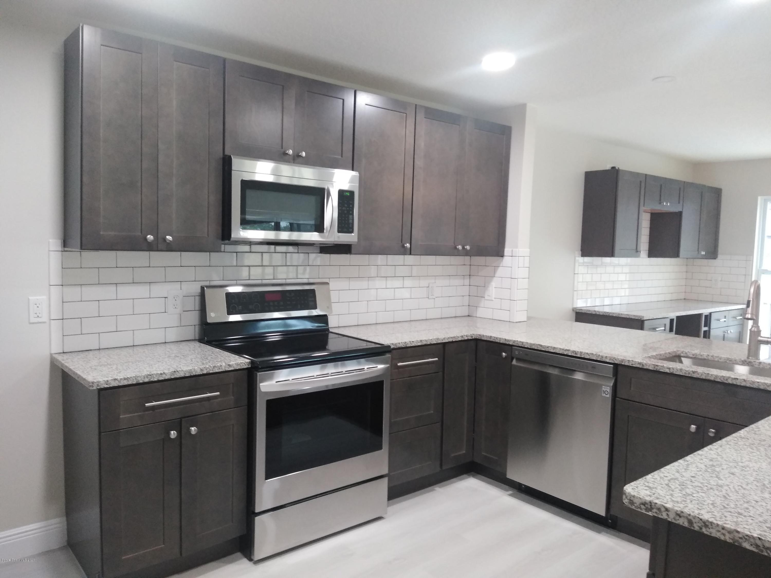 770 Montclair Road Northeast, Unit 1 Palm Bay, FL 32905 - Photo 22 of 23 a kitchen with a sink stove and microwave