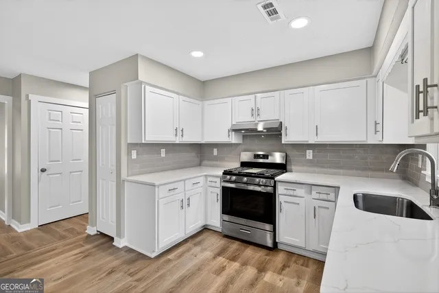 a kitchen with stainless steel appliances kitchen island granite countertop a refrigerator and a sink