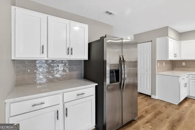a view of a hallway with wooden floor and a living room