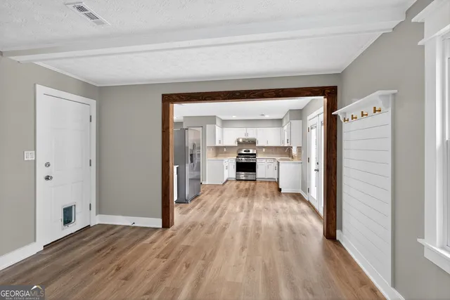 a view of empty room with wooden floor and fireplace