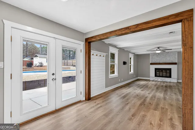 a view of an empty room with a window and wooden floor