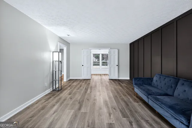 a view of a room with a large window and wooden floor