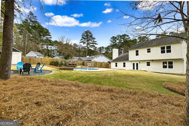 a view of a house with swimming pool and sitting area