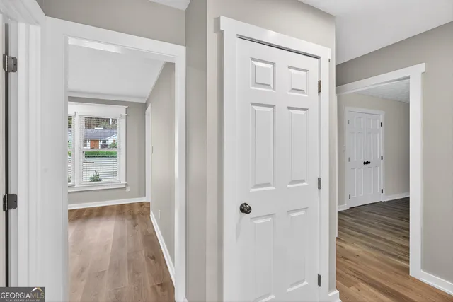 a view of a hallway with wooden floor and closet area