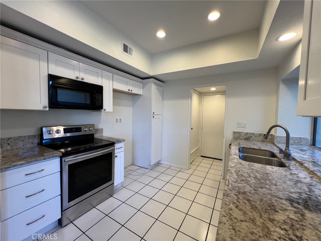 16 Key West Laguna Niguel, CA 92677 - Photo 1 of 23 a kitchen with granite countertop a stove a sink and a microwave