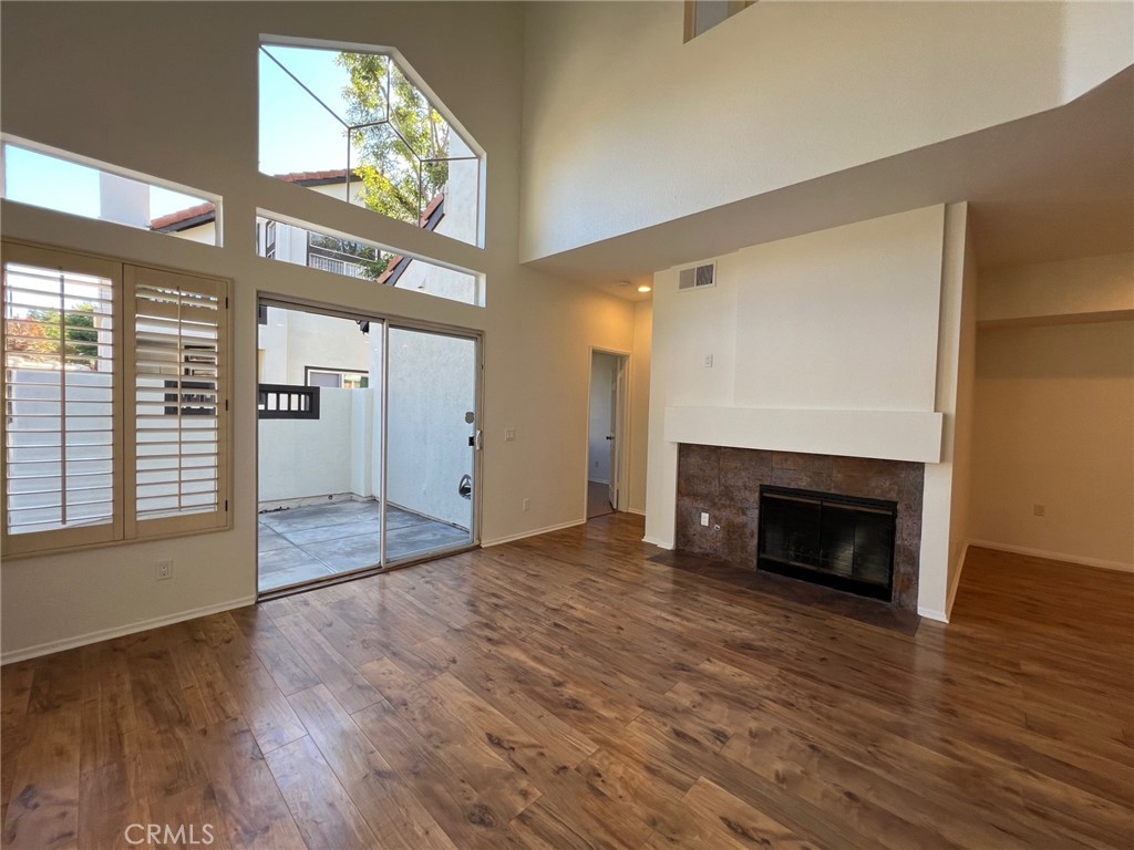 16 Key West Laguna Niguel, CA 92677 - Photo 6 of 23 an empty room with wooden floor fireplace and windows